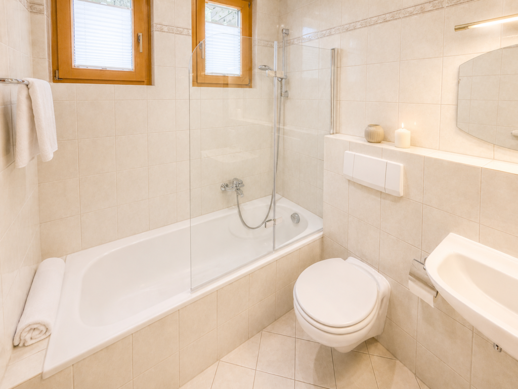 Modernes Badezimmer im Apartmenthaus Das Auss.Zeit mit Dusche, Badewanne, Toilette, Waschbecken und großem Spiegel